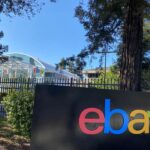An image of an eBay sign with the eBay headquarters behind it
