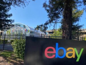 An image of an eBay sign with the eBay headquarters behind it