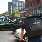 A person riding a bike with an Uber Eats bag on their back