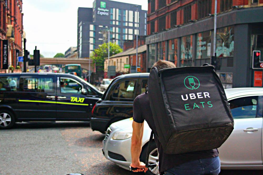 A person riding a bike with an Uber Eats bag on their back
