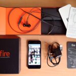 An image of an unboxed Amazon Fire Phone, along with other accessories like a charger and headphones.