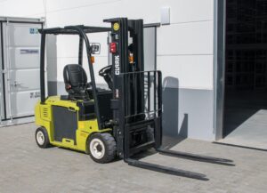 A forklift outside a door next to a shipping container