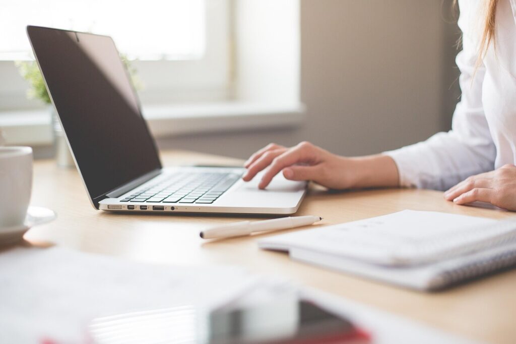 A person sitting at their desk, typing on a computer.