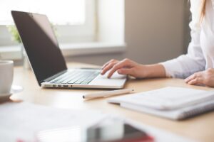 A person sitting at their desk, typing on a computer.