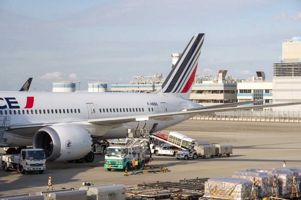 A plane parked at an airport is being loaded or unloaded with cargo.