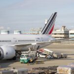 A plane parked at an airport is being loaded or unloaded with cargo.