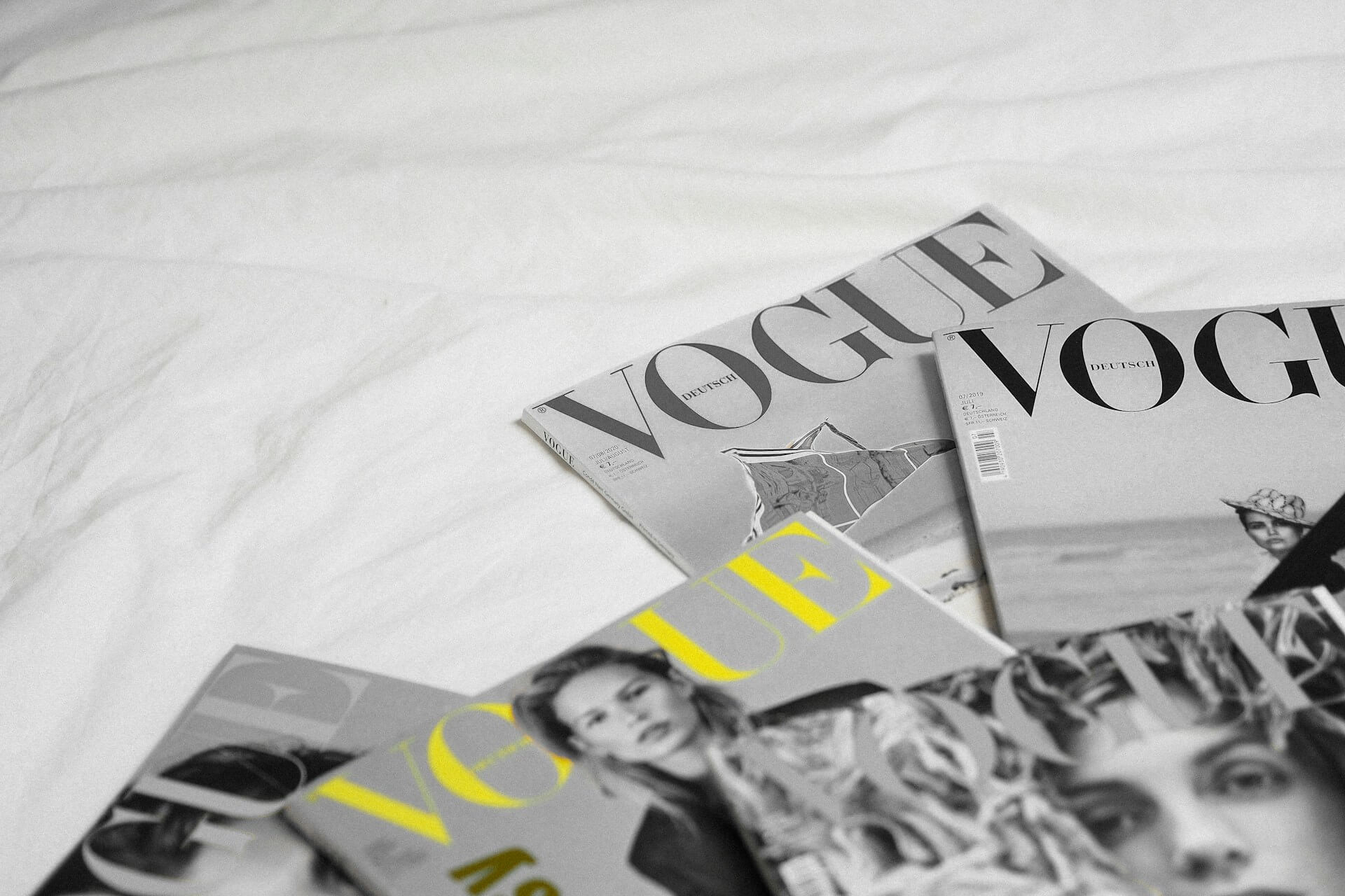 An image of vogue magazines spread out on a table