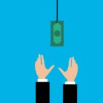 Someone reaching for money that is hanging from a string.