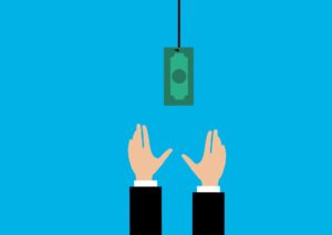 Someone reaching for money that is hanging from a string.