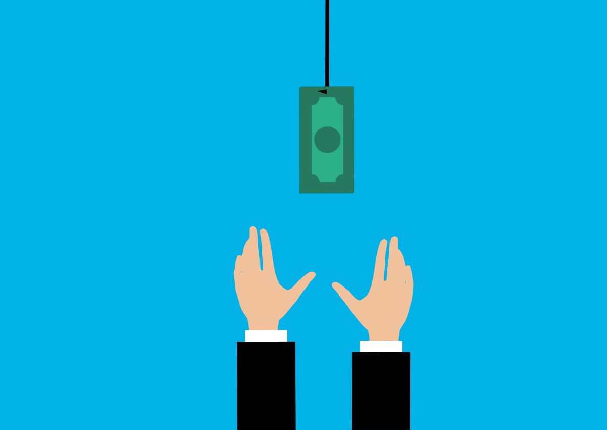 Someone reaching for money that is hanging from a string.