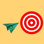 A paper airplane made of money that’s flying towards a target