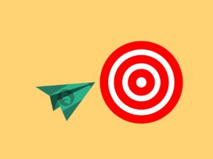 A paper airplane made of money that’s flying towards a target