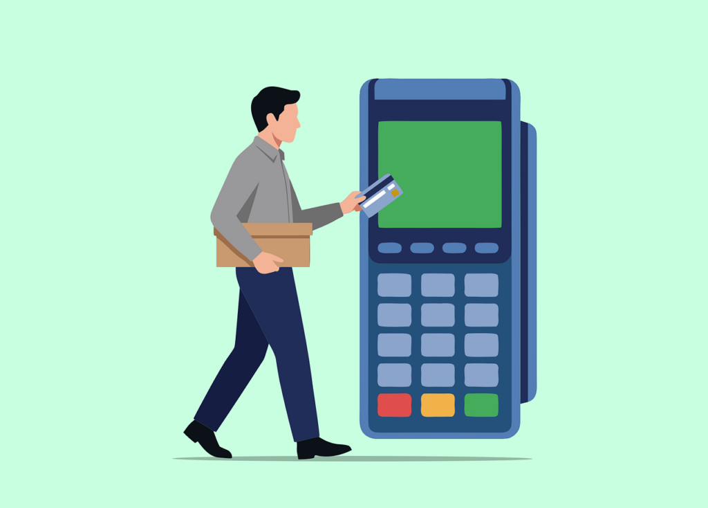 A person holding a box with a credit card in their other hand, walking towards a large card reader or terminal.