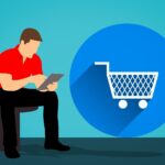 An image of a person sitting on a chair using a mobile device, next to a large circle with a shopping cart in it.