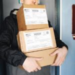 Person holding several packages in cardboard boxes