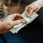 A person giving money to the other person