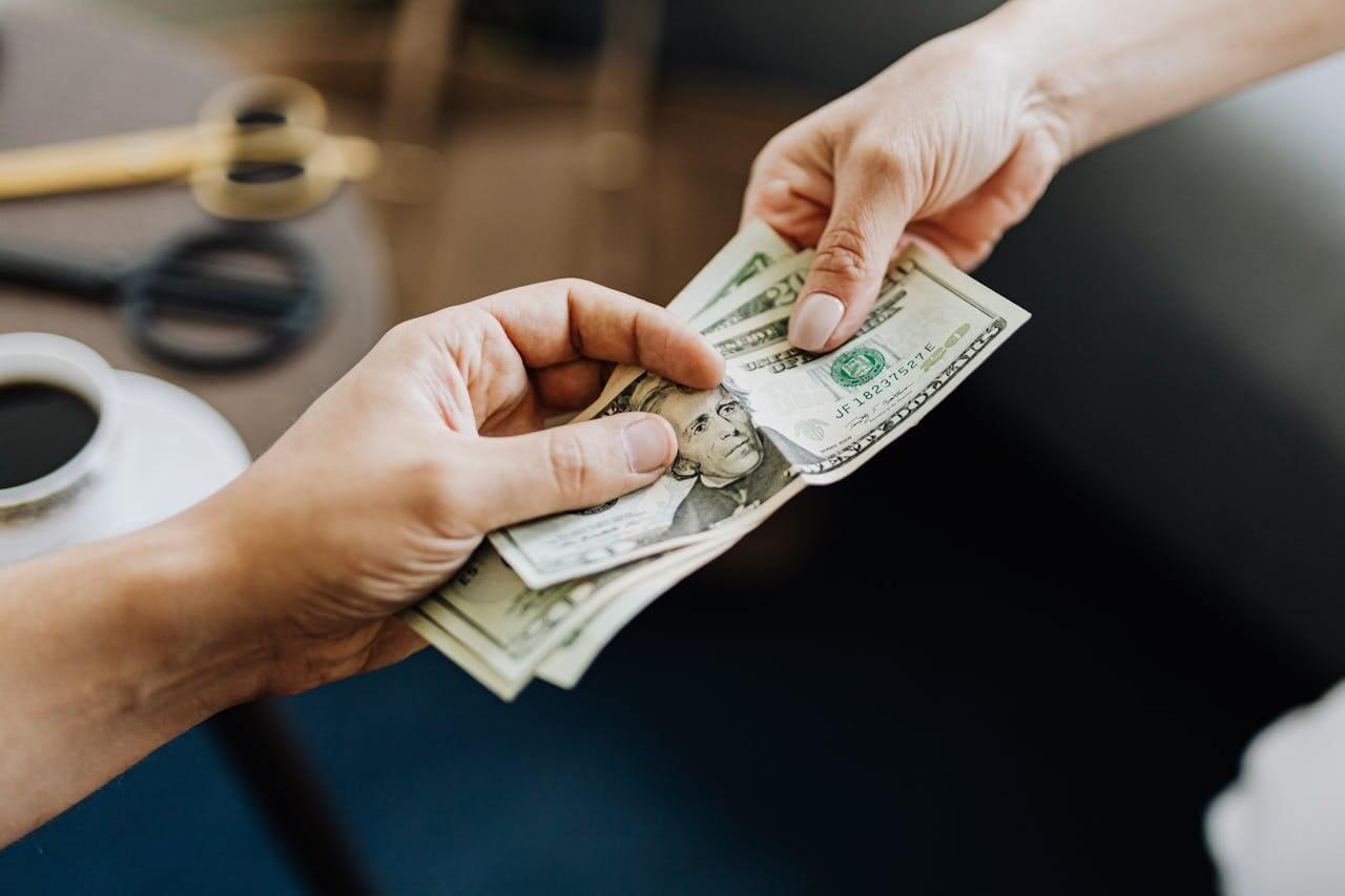 A person giving money to the other person