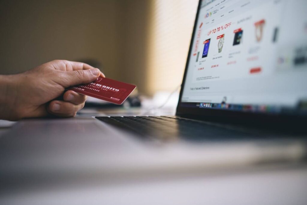 An image showing a person paying online with a card