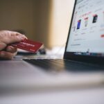 An image showing a person paying online with a card
