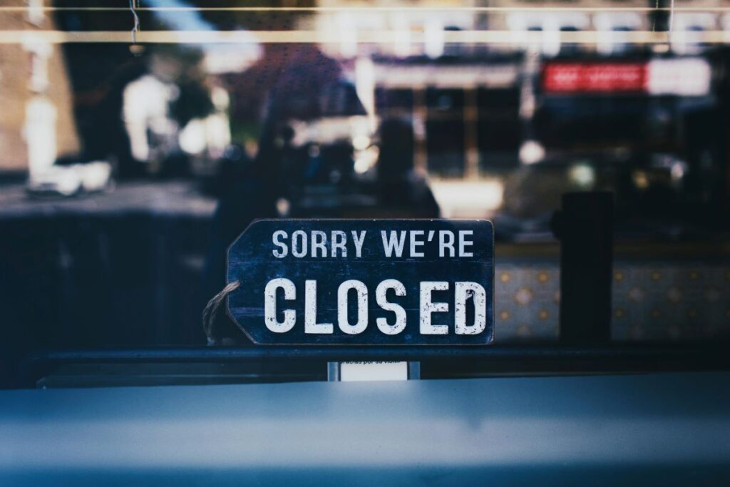 A sign that says Sorry We’re Closed on a glass window