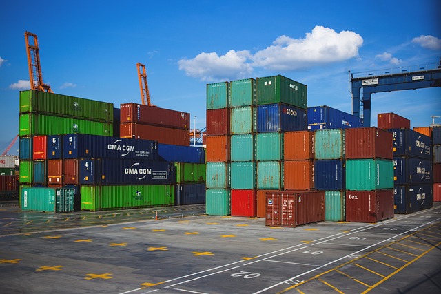 Several large shipping containers stacked on one another, sitting at a port.