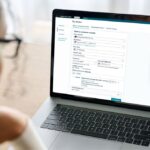 A person looking at their Amazon wallet on a computer screen, with a few types of currencies off to the side.