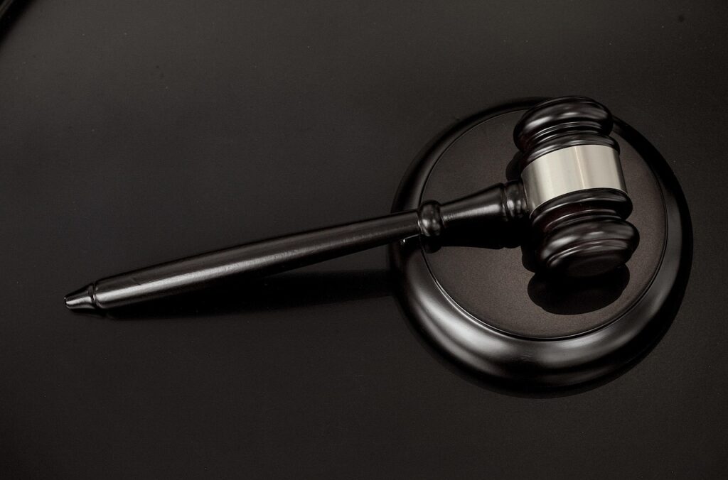 An image of a gavel lying on a sound block