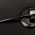 An image of a gavel lying on a sound block