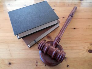 An image of a few books on a table, near a judge’s gavel and sound block.